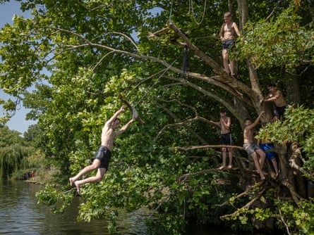 A man swings from a tree into the River Thames near Ham on Tuesday.