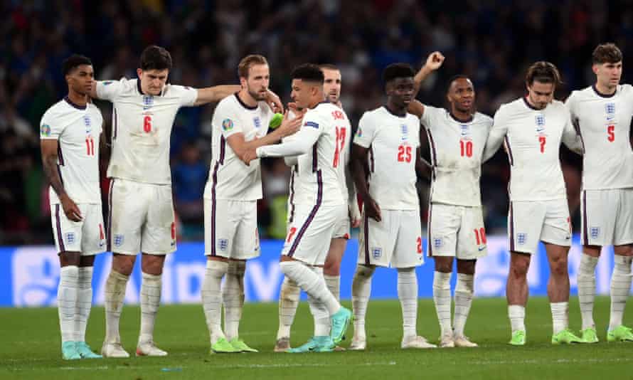 Jadon Sancho of England is consoled by is teammates after failing to score during the penalty shoot out.