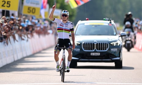 Remco Evenepoel points to the sky as he crosses the finish line.