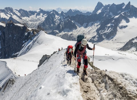 Alpinists walk along a mountain ridge