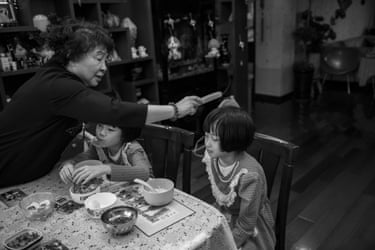 Sheng Hailin combs her daughters’ hair while they are sat at the breakfast table