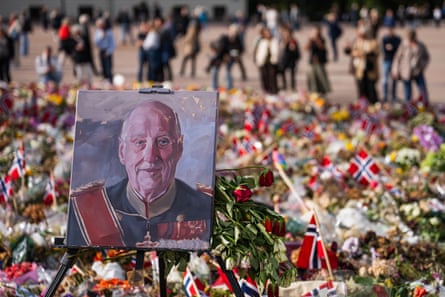 A painted portrait of Norway’s King Harald V is displayed among flowers and Norwegian flags at a makeshift memorial outside the Royal Palace in Oslo, Norway.