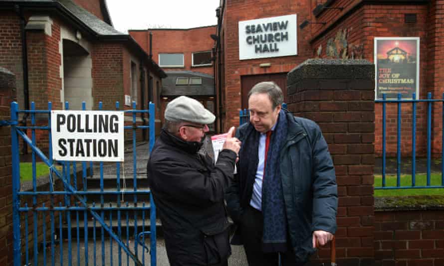 Nigel Dodds chats to local people outside Seaview church hall polling station in north Belfast.