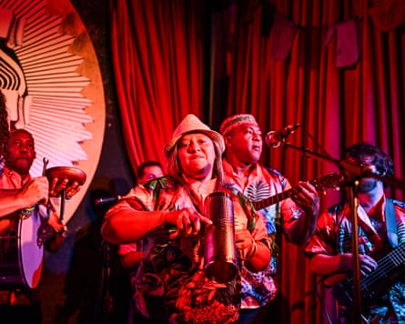 Musicians standing on stage playing instruments