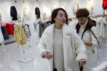 A customer tries on a mink coat at a shopping mall in Shangcun, in China’s Hebei province.