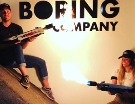 models pose with lighted boring company flamethrowers
