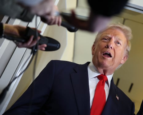 man in suit speaks into microphones