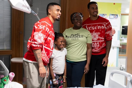Gabriel Jesus (left) and Gabriel Magalhães with a girl and her mother at Great Ormond Street