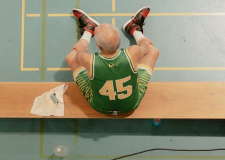 A top down view of Frank Tomasi (83) of the Australia Men’s Over 80 basketball team who sits on the bench during a game