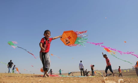 Palestinian children fly kites featuring images of Mohammed El Halabi in Beit Hanoun, Gaza.