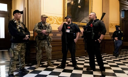 Members of a militia group, including Michael John Null and Willam Grant Null, right, who were charged for their involvement in a plot to kidnap the Michigan governor, stand inside the capitol building in Lansing in April 2020.