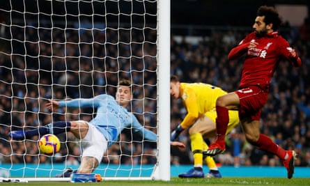 Manchester City’s John Stones clears the ball off the line as Mohamed Salah closes in.