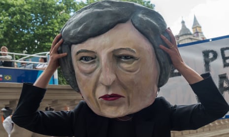 Protester wearing a caricature head of Theresa May