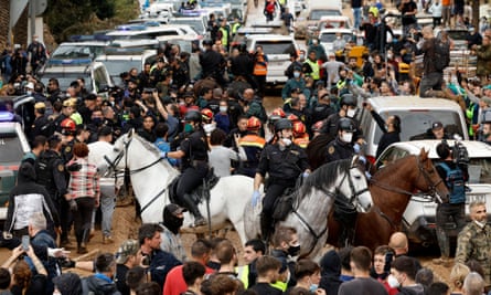 Crowds of people with mounted police officers in the middle