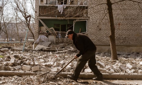 A resident cleans debris of a recently shelled building in Avdiivka, Ukraine.