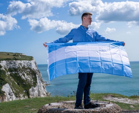 Daniel Jackson holding the blue and white flag of Verdis on the white cliffs of Dover.