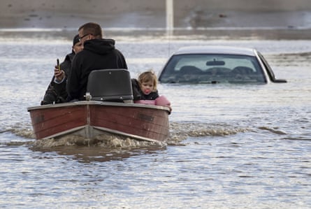 A volunteer uses a boat to rescue people, including a toddler, who were stranded in Abbotsford, British Columbia.