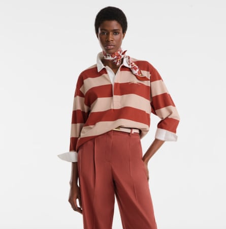 A model wearing an orange striped rugby shirt with coral pants