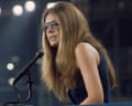 Gloria Steinem, wearing aviator sunglasses, speaks into a microphone at a podium at the Democratic National Convention in 1972.