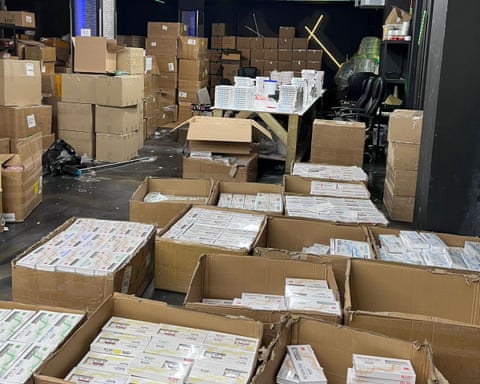 Piles of boxes of packets of drugs in a warehouse.