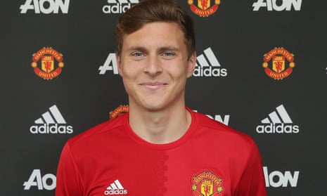 Victor Lindelof poses in a Manchester United shirt after signing for the club at Aon Training Complex.