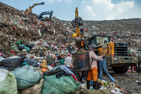 People pick recyclable material from a huge rubbish dump