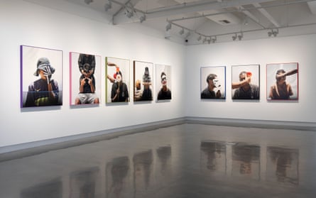 Photo of gallery installation of Hoda Afshar’s portrait photographs, with each subject obscuring their face