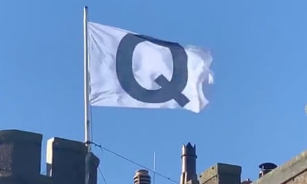 The flag denoting the QAnon conspiracy above the Camelot hotel.