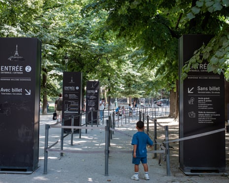 A child stands at an entrance queue area near the Eiffel Tower, which was temporarily closed due to extreme heat.