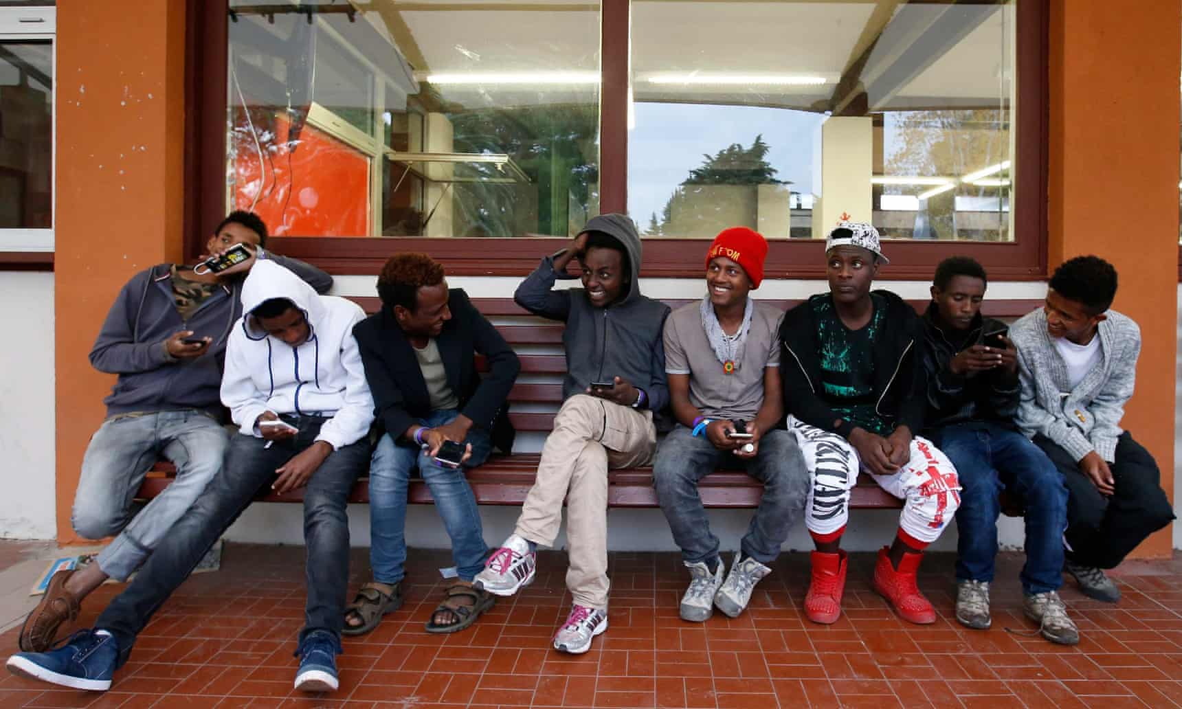 Teenage refugee boys wait at a reception center in Southern France (Photo Courtesy of the Guardian)