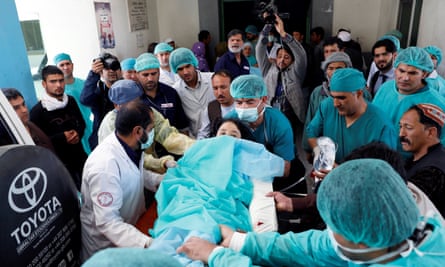 Medics carry an injured woman to the ambulance at a hospital after a suicide attack in Kabul