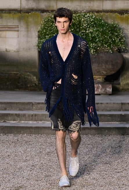 Model in ripped cardigan and shorts
