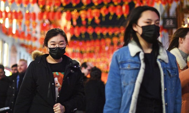 People wear masks in China Town, London, on Saturday. 