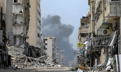 Smoke rises between partly destroyed buildings in Gaza City