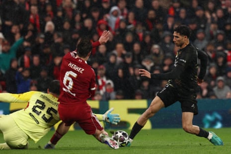 Paris Saint-Germain's Achraf Hakimi (right ) is thwarted by Liverpool's keeper Giorgi Mamardashvili as Milos Kerkez looks on.