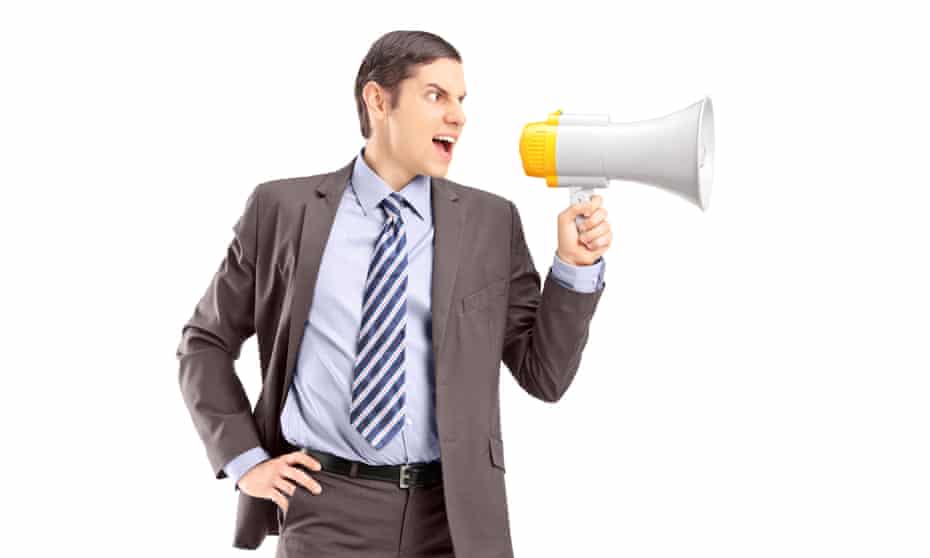 An angry young businessman announcing via megaphone isolated against white backgroundD54NB7 An angry young businessman announcing via megaphone isolated against white background