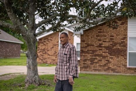 Man stands in front of a house in Garyville, Louisiana.