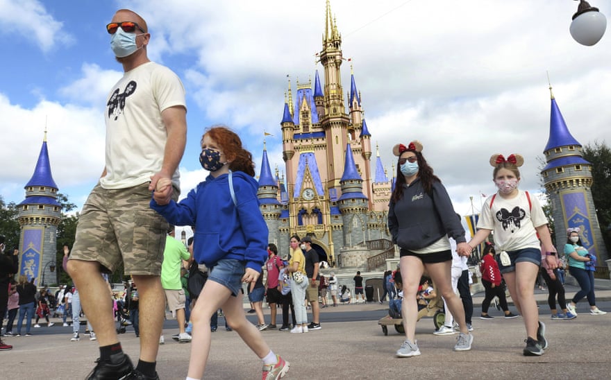 A family wearing masks walks past Cinderella’s castle in the Magic Kingdom, at Walt Disney World in Lake Buena Vista, Florida, on 21 December.