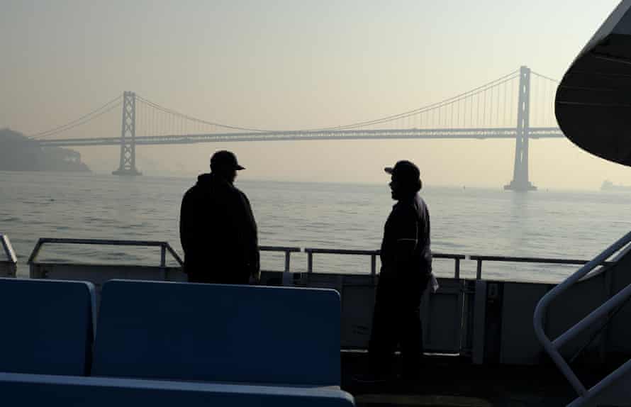 From the deck of a ferry, the San Francisco-Oakland Bay Bridge is obscured.