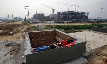 Men rest on a construction site for residential apartments that was halted, unfinished, in 2011.