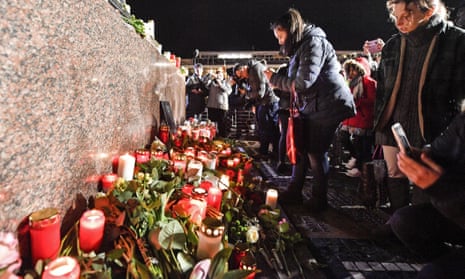 People place candles and flowers in the market place for the victims of the shooting in Hanau, Germany, Thursday, Feb. 20, 2020.