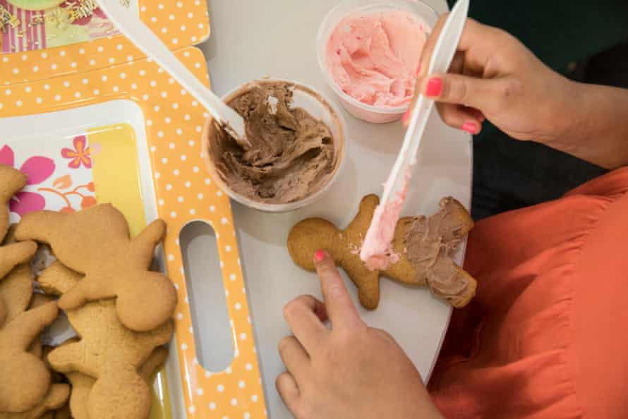A child paints icing on a gingerbread man, one of the activities for kids while visiting their mothers in prison.