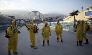 Health workers prepare to spray insecticide at the Sambadrome in Rio, which will be used for the archery competition