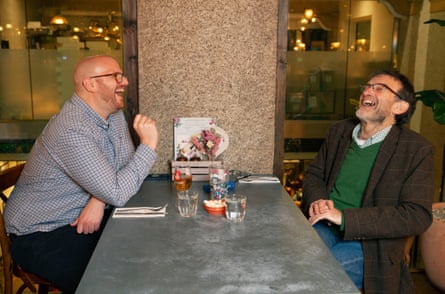 Dua pria saling berhadapan di meja restoran