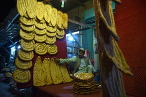 Afghan baker prepares bread at his shop as he waits for customers
