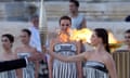Actor Mary Mina, playing an ancient Greek high priestess, holds the torch carrying the Olympic flame at a ceremony in Athens before it began its sea journey to France.