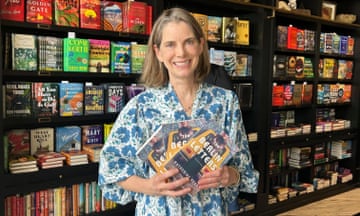 woman in a blue printed dress holding some books