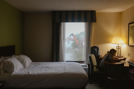 A teenager does homework in a hotel room