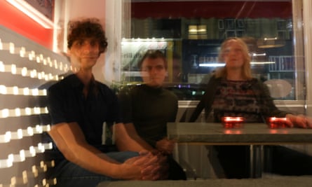 Tara Clerkin Trio sitting around a cafe table, with a blurred effect