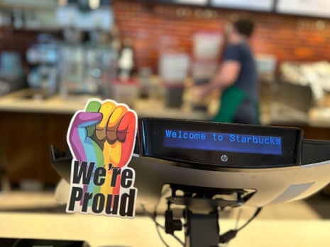pride sticker of clenched fist in rainbow colours on a starbucks cash register